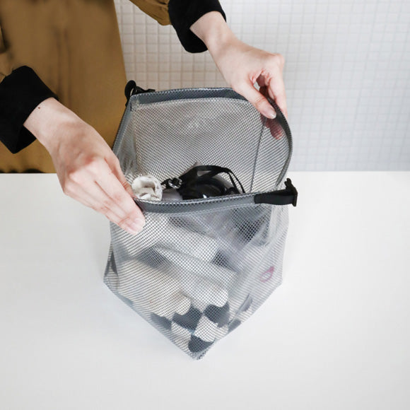 Bolsa organizadora impermeável aberta com grande capacidade interna para guardar roupas, cosméticos ou acessórios.
