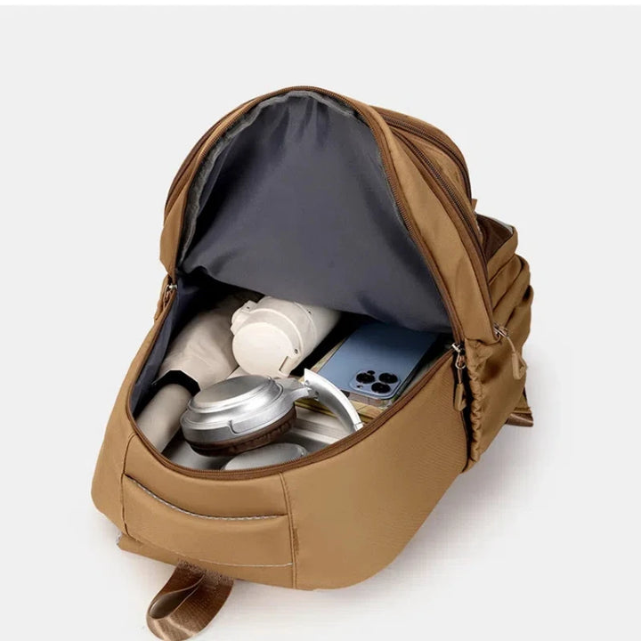 Interior da mochila escolar com divisórias, porta notebook e bolso para celular.